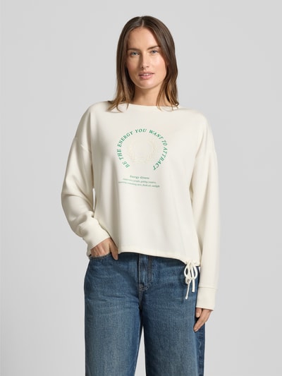 Vrouwenmodel draagt Sweatshirt mit Bändel und Frontprint van Christian Berg Woman, oversized, modal-mix, crèmekleurig, ronde hals, voorkantbedrukking, vooraanzicht bovenlichaam.
