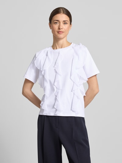 Modelka kobieca ma na sobie T-Shirt mit Rüschen und Rundhalsausschnitt od Christian Berg Woman, biała bawełna, prosty krój, przód pełny kadr.