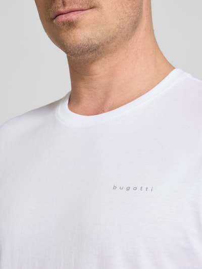 Männermodel trägt T-Shirt mit Label-Detail von bugatti in Weiß, reine Baumwolle, gerader Schnitt, Nahaufnahme Oberkörper.