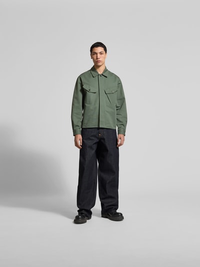 Männermodel trägt Wide Fit Jeans aus reiner Baumwolle von Kenzo in dunklem Denim mit 5-Pocket-Design und Kontrastnähten, Ganzkörperansicht von vorne.