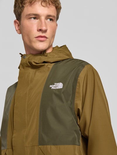Männermodel trägt Jacke mit Label-Stitching Modell 'REIGN ON 2.0' von The North Face in Olivgrün, Nahaufnahme Oberkörper, Regular Fit, Kapuze, verdeckter Reißverschluss