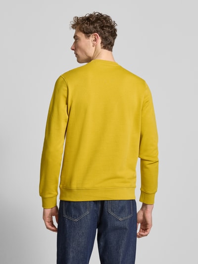 Männermodel trägt Relaxed Fit Sweatshirt aus reiner Baumwolle Modell 'WESTART' von BOSS Orange, unifarbenes Gelb, Sweat-Struktur, Ganzkörperansicht Rückansicht.