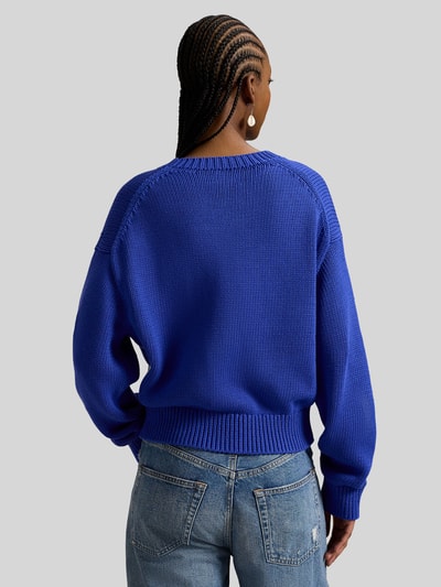 Frauenmodel trägt Regular Fit Strickpullover aus reiner Baumwolle von Polo Ralph Lauren in Two Tone Optik, gerippte Abschlüsse, Ganzkörperansicht Rückansicht.