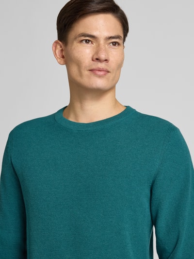 Mężczyzna model nosi Regular Fit Sweter z dzianiny z czystej bawełny od Tom Tailor, efekt: jednolity kolor, dzianina, okrągły dekolt, prążkowane wykończenia, widoczna tekstura materiału, kolor morski, nahaufnahme górnej części ciała.