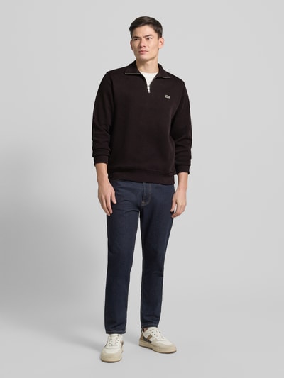 Männermodel trägt Regular Fit Troyer aus reiner Baumwolle von Lacoste, Optik: Unifarben, Strick, Logo-Patch, Ganzkörperansicht von vorne.