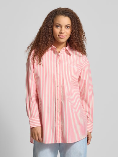 Frauenmodel trägt Oversized Hemdbluse aus Baumwoll-Mix von Tommy Jeans, Optik: Unifarben mit Streifen, Passform: Oversized, Hemdkragen, Label-Schriftzug, Rückenpasse, einreihige Knopfleiste, Langarm mit Manschette, Rumpfabschluss leicht abgerundet, Materialverarbeitung: Popeline, Nahaufnahme Oberkörper.
