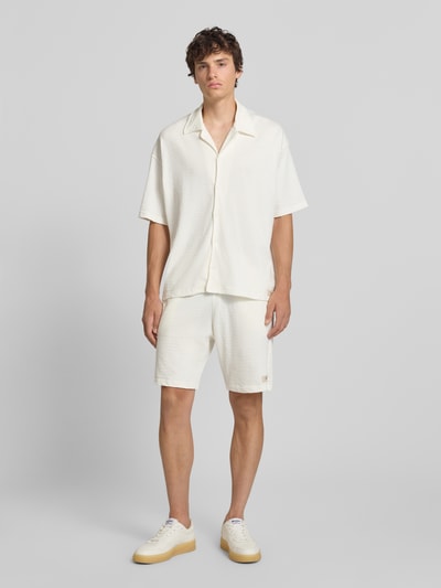 Männermodel trägt Regular Fit Freizeithemd mit Reverskragen Modell 'Arcos' von PEGADOR in Creme, reine Baumwolle, Ganzkörperansicht von vorne.
