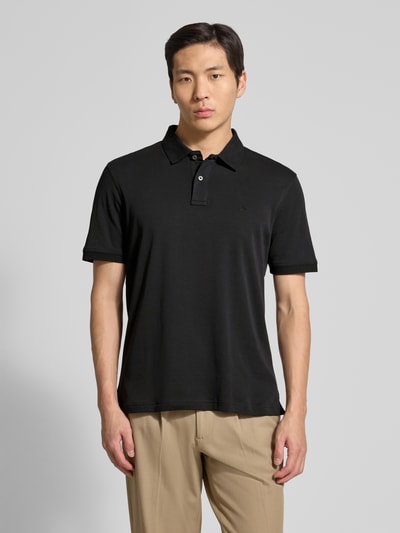 Männermodel trägt Regular Fit Poloshirt mit Logo-Stitching von Fynch-Hatton in Schwarz, reine Baumwolle, Polokragen, Ganzkörperansicht von vorne.