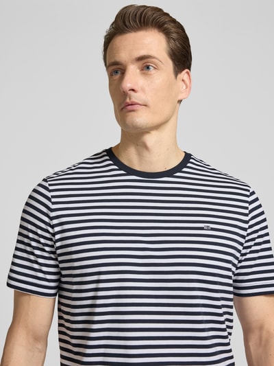 Männermodel trägt Regular Fit T-Shirt Mit Logo-Stitching von Christian Berg Men, reine Baumwolle, Nahaufnahme Oberkörper.