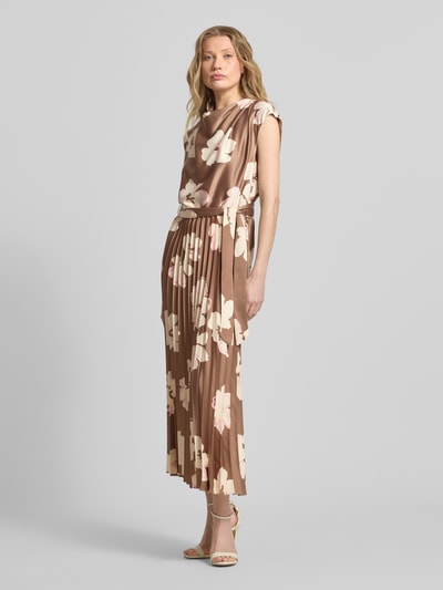 Frauenmodel trägt Regular Fit Satinkleid mit Plissee von s.Oliver BLACK LABEL in Braun mit Allover-Muster, Elastikbund, Midi-Länge, Wasserfall-Ausschnitt, florales Muster, ohne Ärmel, Satin und Plissee-Rockteil, Ganzkörperansicht von vorne.