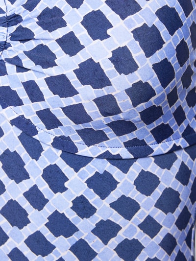 Frauenmodel trägt Slim Fit Badeanzug mit Ziersteinbesatz Modell 'Marseille' von Seafolly aus Elastischer-Material-Mix mit blauem Muster, Nahaufnahme Oberkörper.