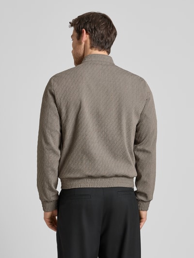 Männermodel trägt Jacke aus Schurwoll-Mix mit Zweiwege-Reißverschluss von Emporio Armani in Beige, strukturiertes Material, Rückansicht Ganzkörperansicht. Regular Fit, Stehkragen, Stretch-Anteil, Eingrifftaschen, bei Größe 50 Rückenlänge 63 cm, Schulterbreite 45 cm, Brustweite 53 cm, Ärmellänge 67 cm.