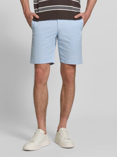 Männermodel trägt Regular Fit Bermudas aus Baumwoll-Mix von Tommy Hilfiger, Optik: Unifarben, Logo-Stitching, Hellblau, Ganzkörperansicht von vorne.