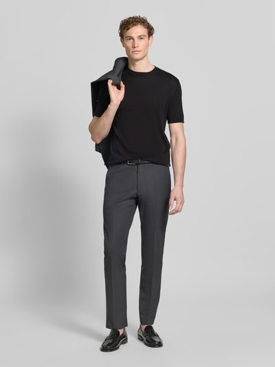 Männermodel trägt Strickshirt mit Rundhalsausschnitt von MARKUP in Schwarz, kombiniert mit grauer Hose, Ganzkörperansicht von vorne.