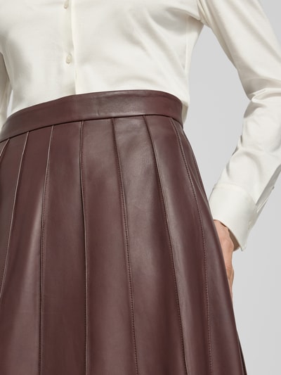 Frauenmodel trägt Ausgestellter Lederrock mit Reißverschluss Modell 'SEVARA' von BOSS, Optik: Unifarben, Passform: Regular-Fit, Midi-Länge, Materialverarbeitung: Glattleder, Material: Rindsleder, Nahaufnahme Oberkörper.