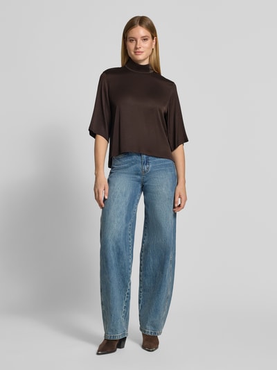 Frauenmodel trägt Regular Fit Bluse mit Stehkragen Modell 'Aletia' von DRYKORN, elastischer Acetat-Mix, dunkelbraun, Ganzkörperansicht von vorne.