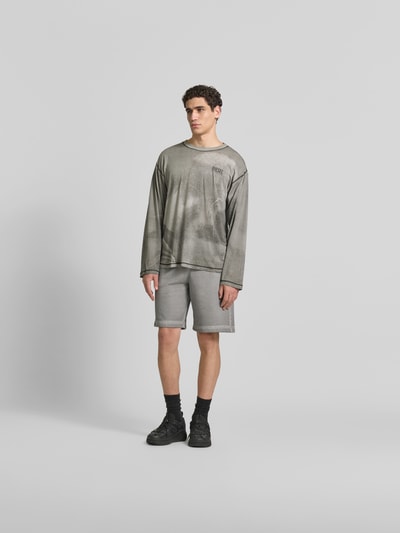 Männermodel trägt Regular Fit Longsleeve aus Hanf-Mix von Diesel im Used-Look, Rundhalsausschnitt, Label-Print, Ganzkörperansicht von vorne.