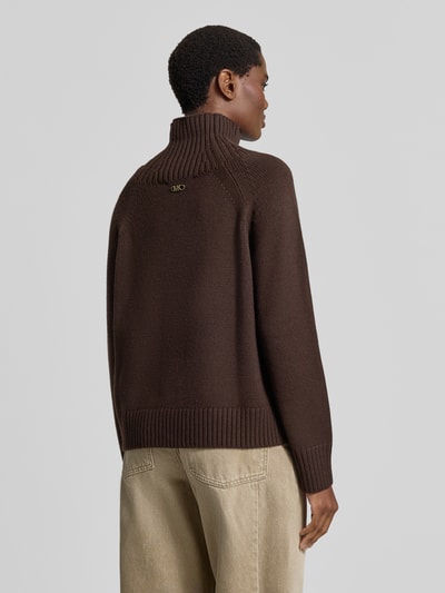 Frauenmodel trägt Strickpullover aus reinem Leinen von MICHAEL Michael Kors in Dunkelbraun, lockere Passform, gerippte Abschlüsse, Ganzkörperansicht Rückansicht.