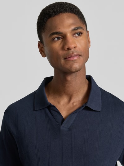 Männermodel trägt Regular Fit Poloshirt in Jaquard-Strick von Lindbergh in Dunkelblau, Reine Baumwolle, Nahaufnahme Oberkörper.