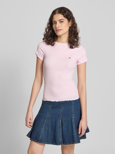 Frauenmodel trägt Slim Fit T-Shirt aus Baumwoll-Mix von Tommy Hilfiger in Rosa mit Logo-Detail, Frill-Ärmel, Feinripp, Ganzkörperansicht von vorne.
