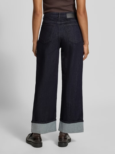 Frauenmodel trägt Wide Leg Jeans aus Baumwoll-Mix Modell 'Miva city' von OPUS in dunklem Denim mit fixiertem Umschlag, 5-Pocket-Design, Ganzkörperansicht Rückansicht.