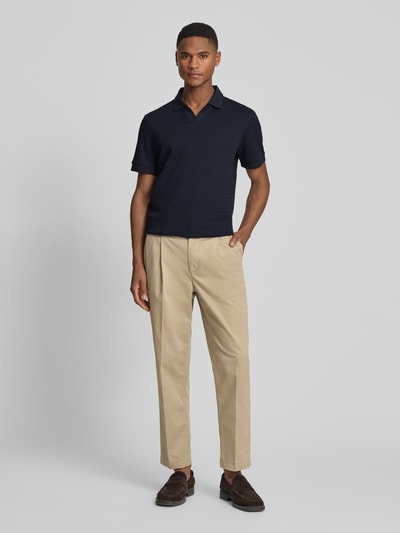 Mężczyznę model nosi koszulkę polo z bawełny o kroju regular fit, model 'Rauljose' od JOOP! kolekcja, fakturowany wzór, dekolt w serek, długość tyłu w rozmiarze M: 69 cm, całkowity widok z przodu.