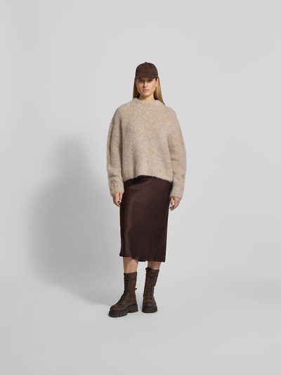 Frauenmodel trägt Seidenrock in Midi-Länge von Anine Bing aus reiner Seide in Braun, schmale Passform, elastischer Bund, Ganzkörperansicht von vorne.