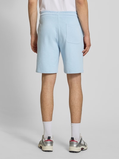 Männermodel trägt Sweatshorts mit Logo Model 'KANE' van Jack & Jones, katoenmix, relaxed fit, elastische band, lichtblauw, Ganzkörperansicht Rückansicht.