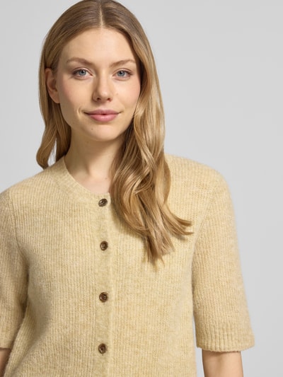 Frauenmodel trägt Cardigan aus Woll-Mix mit 1/2-Arm Modell 'Thora' von MOS MOSH, Regular-Fit, Rundhalsausschnitt, Nahaufnahme Oberkörper. Textur weicher Woll-Mix mit Alpaka-Anteil, beige meliert, Rückenlänge bei Größe S: 59 cm, Ärmellänge: 30 cm.