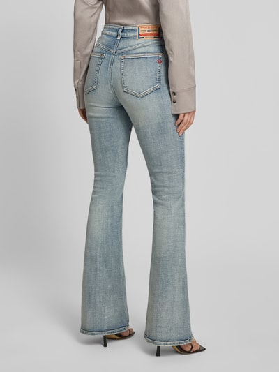 Frauenmodel trägt Flared Fit Jeans mit Logo-Detail von Diesel im typischen 5-Pocket-Design, Baumwoll-Mix, hellblaue Waschung, Ganzkörperansicht Rückansicht.