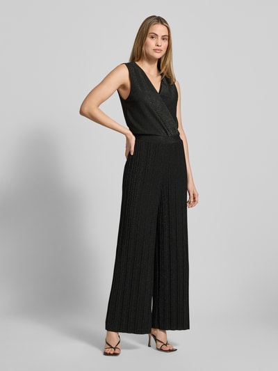 Vrouwenmodel draagt glanzende dames jumpsuit van ZABAIONE Model 'Li44ana', materiaalmix met stretch, regular fit, V-hals, zwart, glanzende textuur, totale lengte 150 cm, borstwijdte 45 cm, binnenbeenlengte 77 cm, ruglengte 29 cm, geheel van voren bekeken.
