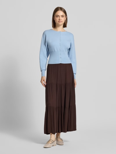 Frauenmodel trägt ausgestellten, unifarbenen Maxi-Rock aus reiner Viskose mit Crinkle-Textur und Volants, Modell 'MIKKA' von Only, Ganzkörperansicht von vorne.