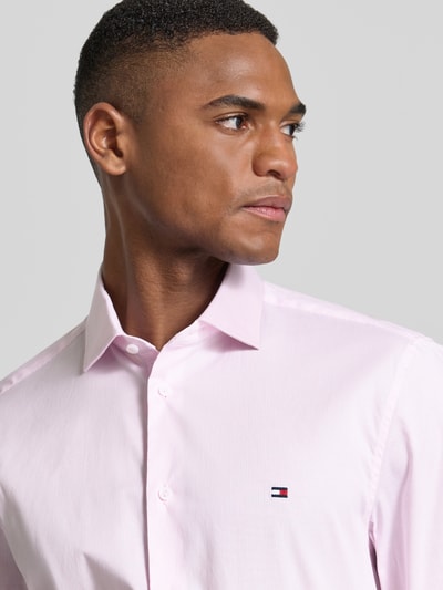 Männermodel draagt Slim Fit Businesshemd aus Baumwoll-Mix von Tommy Hilfiger, all-over motief, kentkraag, gestreept, logostitching, lange mouw, doorlopende knoopsluiting, katoenmix, nahaufnahme oberkörper.