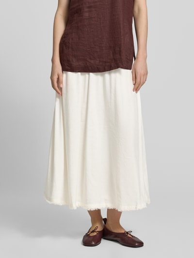 Frauenmodel trägt Midi-Rock aus reinem Leinen von Tommy Hilfiger in Creme, unifarben, ausgestellte Passform, Fransen-Saum, Nahaufnahme Unterkörper.