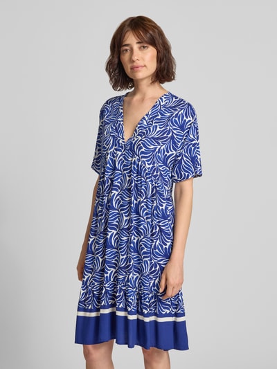 Frauenmodel trägt Knielanges Kleid aus Viskose Modell 'Me44la' von ZABAIONE mit blau-weißem Allover-Muster, A-Linie, V-Ausschnitt, Kurzarm, Ganzkörperansicht von vorne.