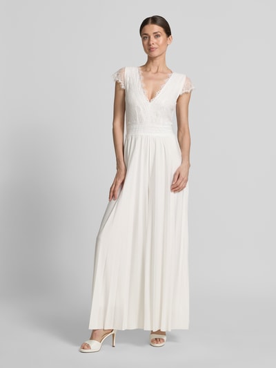 Vrouwenmodel draagt Braut-Jumpsuit met diepe V-hals, model 'Emmie' van GUIDO MARIA KRETSCHMER WOMAN, rechte fit, top van kant, plissé broekdeel, witte kleur, tailleband, lengte 143 cm, voorkant volledige lichaamsweergave.