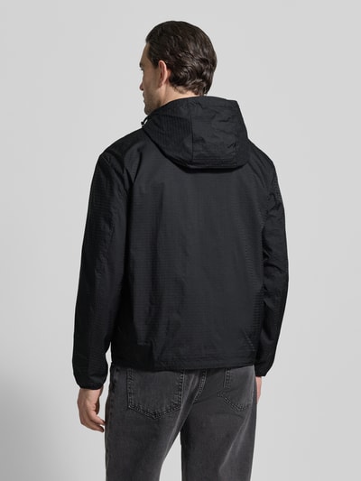 Männermodel trägt schwarze Jacke mit Zweiwege-Reißverschluss von Emporio Armani, Kapuze, Reißverschlusstaschen, Ganzkörperansicht Rückansicht.