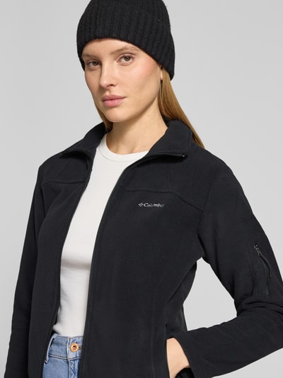 Frauenmodel trägt schwarze Slim Fit Fleecejacke mit Ärmeltasche Modell 'Fast Trek™ II' von Columbia, Fleece, Nahaufnahme Oberkörper.