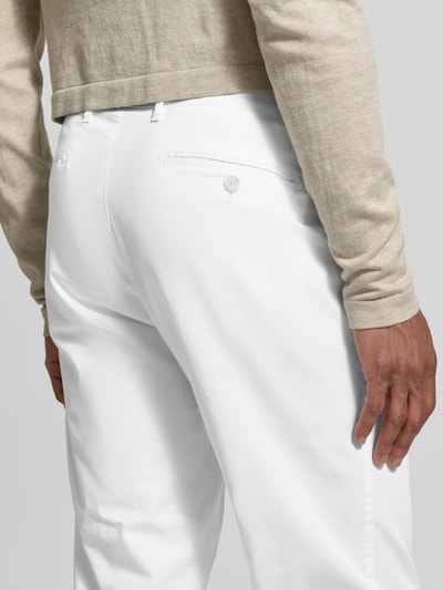 Männermodel trägt weiße Straight Fit Stoffhose mit Lyocell-Anteil Modell 'Everest' von Brax, Gesäßtaschen, Nahaufnahme Rückansicht.