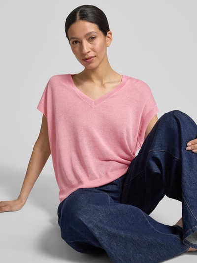 Frauenmodel trägt Strickshirt aus Leinen-Mix mit V-Ausschnitt von Comma, relaxed Fit, in Rosa, Kappärmel, Ganzkörperansicht von vorne.