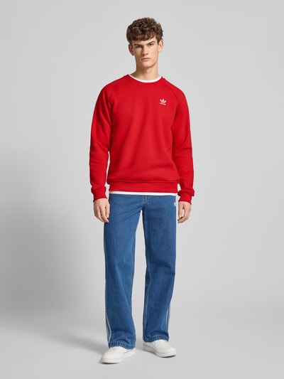Männermodel trägt Sweatshirt mit Logo und Rundhalsausschnitt von adidas Originals, rot, Regular Fit, Baumwoll-Elasthan-Mix, Ganzkörperansicht von vorne