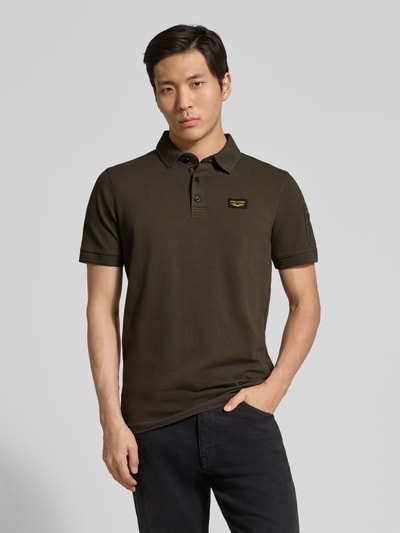 Männermodel trägt Slim Fit Poloshirt mit Label-Stitching Modell 'TRACKWAY' von PME Legend aus Baumwoll-Elasthan-Mix, Knopfleiste, dunkle Farbe, Rückenlänge bei Größe M 74 cm, Ganzkörperansicht von vorne.