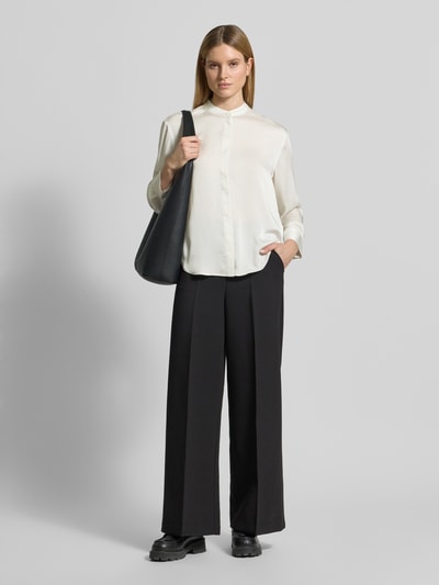 Frauenmodel trägt Relaxed Fit Bluse mit Stehkragen von Calvin Klein Womenswear aus cremefarbenem Satin, Langärmelig, Ganzkörperansicht von vorne.