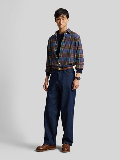 Männermodel trägt Custom Fit Freizeithemd aus reiner Baumwolle von Polo Ralph Lauren mit Karomuster in Blau und Braun, Ganzkörperansicht von vorne. Herren Freizeithemd von Polo Ralph Lauren.
