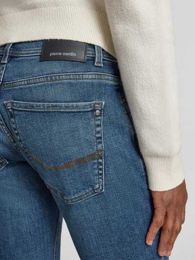 Männermodel trägt Tapered Fit Jeans im 5-Pocket-Design Modell 'Lyon' von Pierre Cardin, blauer Baumwoll-Mix mit Stretch-Anteil, Nahaufnahme Rückansicht.