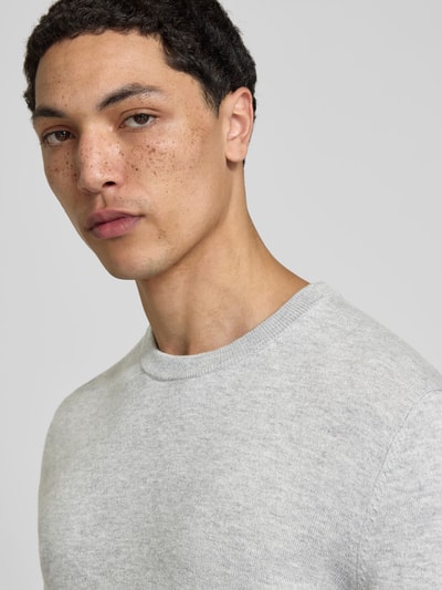 Männermodel trägt Slim Fit Pullover aus Woll-Mix von Filippa K in Hellgrau, Strick-Optik, Rundhalsausschnitt, Nahaufnahme Oberkörper.