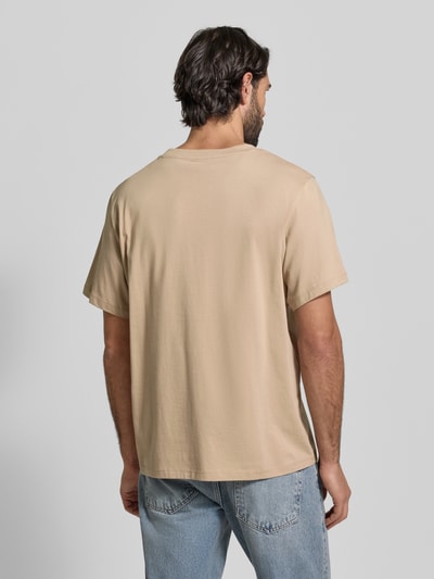 Męski model ma na sobie Regular Fit T-Shirt aus reiner Baumwolle Modell 'ASPAN' od SELECTED HOMME, jednolity beżowy kolor, krótki rękaw, okrągły dekolt, materiał jersey, widok całej sylwetki z tyłu.