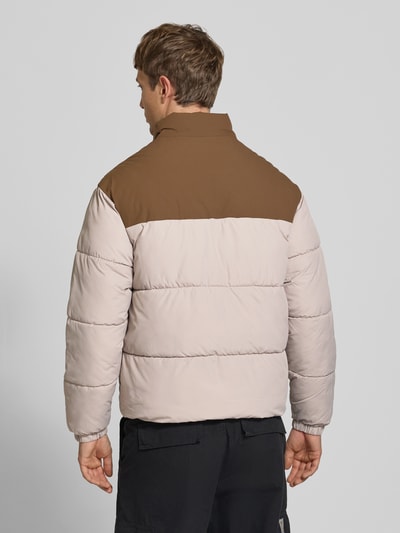 Männermodel trägt Steppjacke mit Stehkragen Modell 'RAZE' von JACK & JONES in Beige und Braun, Rückenansicht, Ganzkörperansicht Rückansicht. Reguläre Passform, Reißverschluss, Eingrifftaschen, samt glatter, wattierter Oberfläche, Rückenlänge, Schulterbreite, Brustweite und Ärmellänge laut Beschreibung.