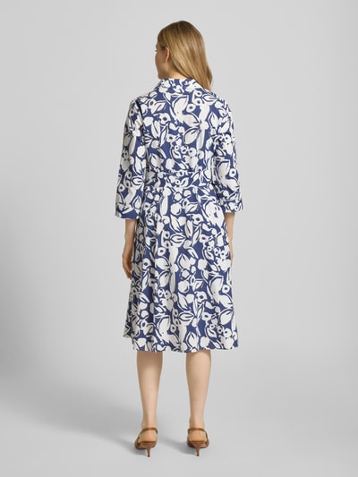 Modelka nosi sukienkę midi z mieszanki bawełny i elastanu 'Midikleid aus Baumwoll-Mix' od More & More, wzór kwiatowy, krój taliowany, wykładany kołnierz, listwa guzikowa, tasiemka w talii, rękaw o dł. 3/4, długość tyłu w rozmiarze 36: 120 cm, szerokość w rozmiarze 36: 42 cm, długość rękawów w rozmiarze 36: 50 cm. Ganzkörperansicht Rückansicht