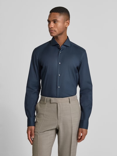 Männermodel trägt Slim Fit Business-Hemd mit Stretch-Anteil Modell 'Hank Hai' von BOSS, unifarben, Haifischkragen, Ganzkörperansicht von vorne.
